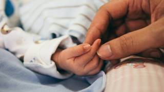 new born hand being held by mother