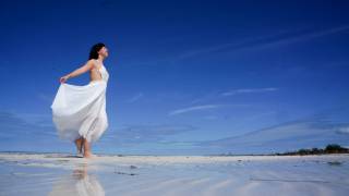 woman on beach celebrating the sun