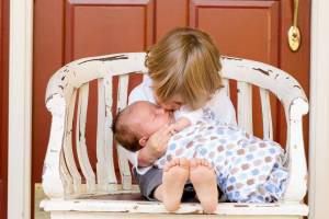 older sibling holding new baby brother