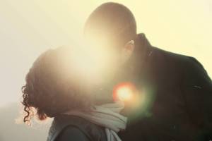 happy couple kissing in the sunlight
