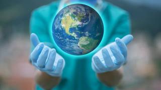 person with gloves holding the world 