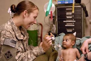 army doc helping a little toddler