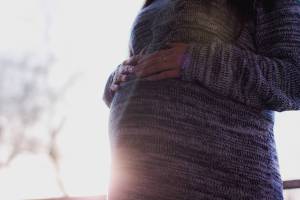belly of a pregnant women with the sun shining on it