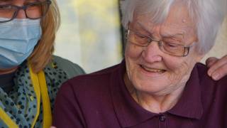 health care worker look at test results with a resident of the nursing home