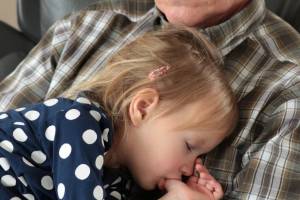 grandpa holding a sleeping grandchild