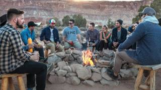 group of people sitting around a camp fire