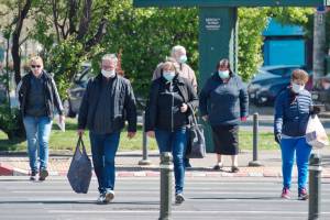 people wearing masks crossing the road