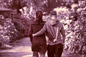 coupke walking in the park with arems around each other
