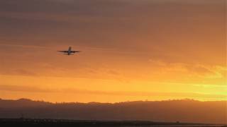 plane taking off in the sun set