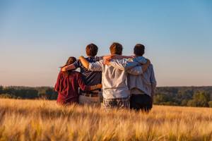 teens holding each other standing in a field
